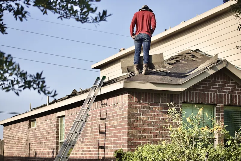Professional roofer working on a residential roof in Gentry